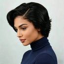 Woman with styled black hair wearing a blue turtleneck against a light gray background, Obroi