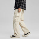 Person wearing beige cargo pants and a plaid shirt on a plain background, Obroi