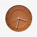 A minimalist round wall clock with a terracotta brown face and white hands, shown against a solid white background, Obroi