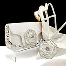 White clutch bag with floral embellishments and white high-heeled shoes on a clear stand, Obroi