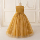 Mustard yellow dress with a bow on a mannequin against a white paneled wall, Obroi