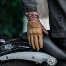 Brown leather glove on a motorcycle seat with a blurred background, Obroi