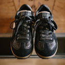 Pair of black leather shoes with brown soles on a wooden surface, Obroi