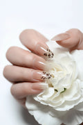 Nails with a nude color and leopard print design on a white background, Obroi