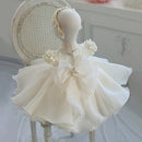 White children's dress with floral details on a mannequin against a light background, Obroi