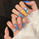 Close-up of hands with colorful nail art featuring flowers and stars.