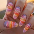 Nails with colorful watercolor design held against a blurred natural background, Obroi