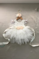 White tutu dress with floral details on a hanger against a gray background, Obroi