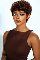 Woman with short, curly brown hair wearing a brown dress against a white background, Obroi