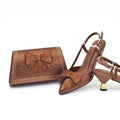 Brown high-heeled shoes and matching clutch with decorative bow on a white background, Obroi