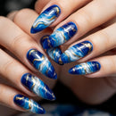 Close-up of hands with blue marbled nail art on a blurred background, Obroi