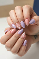 Close-up of hands with pastel pink and purple nail polish, Obroi