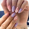 Close-up of hands with pastel pink and purple nail polish, Obroi
