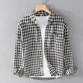 Black and white checkered shirt on a hanger against a gray background, Obroi