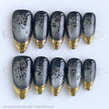 Set of decorative nails with gold and black designs on a white background, Obroi