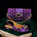 A purple and iridescent sequined clutch bag with a gold chain strap and matching embellished slingback shoe displayed on a green velvet surface against a black background, Obroi