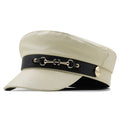 Beige cap with black band featuring gold hardware on a white background, Obroi