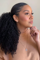 Woman with styled hair and two ponytail extensions on a white background, Obroi