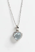 Heart-shaped pendant with clear gemstone on a chain against a white background, Obroi