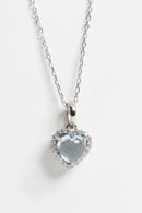 Heart-shaped pendant with clear gemstone on a chain against a white background, Obroi