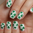 Nails with green shamrock designs on a white background, Obroi