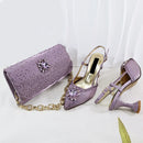 A coordinated women's accessory set in lavender purple, including a studded clutch bag with a gold chain strap, a pointed-toe slingback high heel, and a flat slingback high heel, both with jeweled embellishments. The insoles show the brand name , Obroi