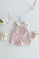 Pink floral baby romper on a hanger with baby shoes and toys on a light gray background, Obroi