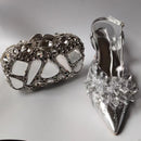 Silver high-heeled shoe with decorative crystal embellishments on a gray background, Obroi