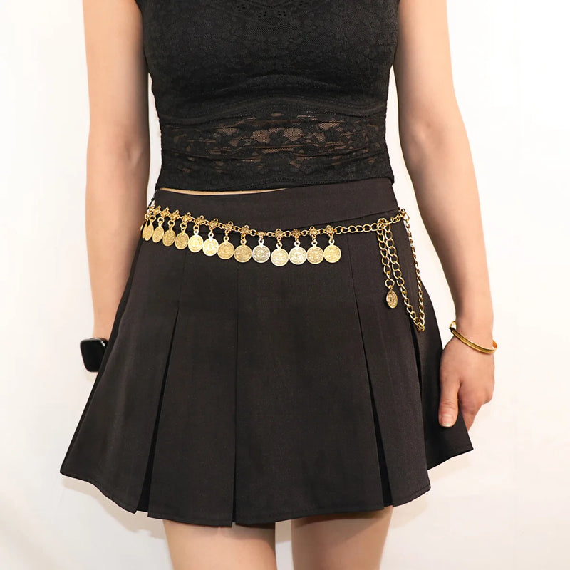 Person wearing a black skirt with a gold chain belt on a white background, Obroi