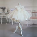 White dress on a mannequin in a room with tables and chairs, Obroi