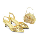 Obroi Gold high-heeled shoes with embellishments and a matching handbag on a white background.