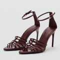 Pair of maroon high-heeled sandals with thin straps on a light gray background, Obroi