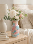 Decorative vase with flowers on a nightstand next to a lamp and books, Obroi