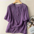 Purple embroidered blouse on a wooden hanger against a light background, Obroi