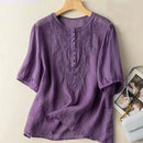 Purple embroidered blouse on a wooden hanger against a light background, Obroi