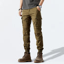 Person wearing olive green cargo pants and brown boots on a light gray background, Obroi