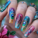 Nails with peacock feather design and glittery finish, held against a blurred floral background, Obroi