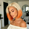 A woman wearing a short bob haircut with a blonde top fading into bright orange at the ends, photographed indoors in a modern living room setting, Obroi