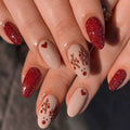 Close-up of hands with red and beige nail designs, Obroi