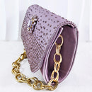 A lavender purple satin clutch bag embellished with silver rhinestones and a gold-tone chain strap, shown on a white background, Obroi