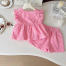 Pink children's outfit with top and shorts on a white surface, Obroi