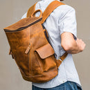 Person wearing a brown leather backpack on a plain background, Obroi