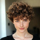 Person with curly hair wearing a black top against a blurred background, Obroi
