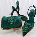 Green high-heeled shoes and matching handbag with embellishments on a white background, Obroi