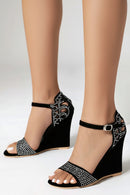 Black wedge sandals with rhinestone details worn by a person on a white background, Obroi