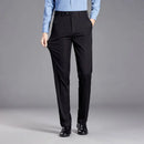 Person wearing black dress pants with a gray background, Obroi