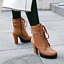 Brown lace-up boots with a block heel worn outdoors on a pavement, Obroi