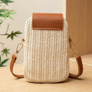Woven handbag with brown leather accents on a wooden surface, Obroi