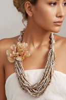 Necklace with floral pendant worn by a person, Obroi