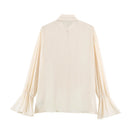 A cream-colored long-sleeve blouse with gathered cuffs and a split V-neckline, shown from the back on a plain white background, Obroi
